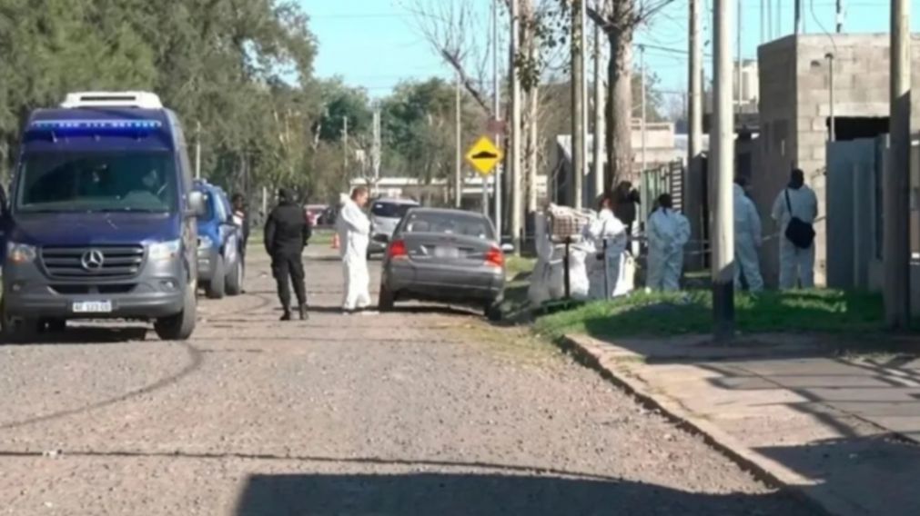 Peritos trabajan frente a la casa en la que fueron hallados los cadáveres.