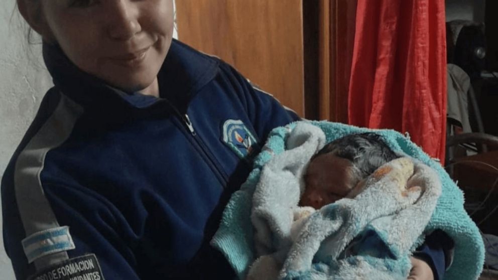 La uniformada junto al recién nacido.