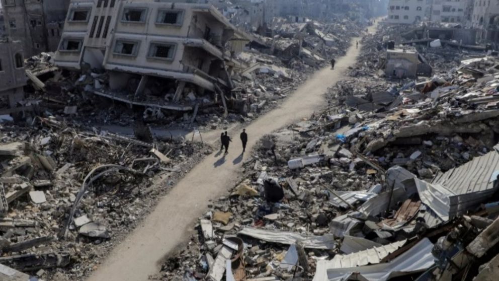 Palestinos caminan en medio de viviendas destruidas en la Franja de Gaza (Gentileza France 24).