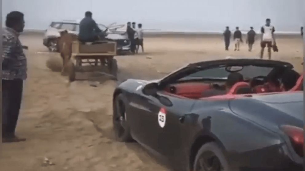 Un auto Ferrari modelo California T quedó varado en la playa y lo remolcaron con bueyes (X).