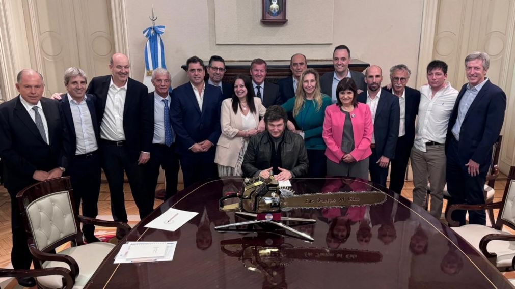 Javier Milei junto a su equipo de funcionarios y la motosierra.