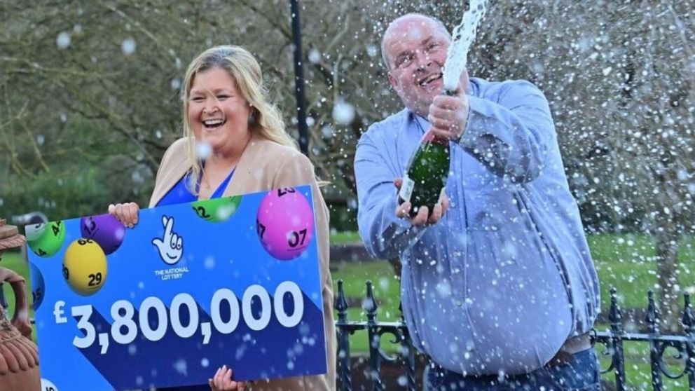 El matrimonio posó con el cheque del premio que ganó en la lotería.