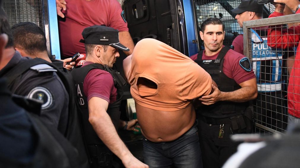El momento en el que la Policía baja de un móvil a uno de los acusados (Télam).