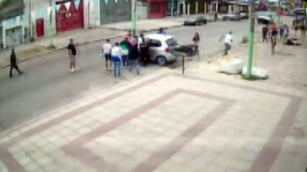 Amigos de la joven fallecida rodean el auto que unos segundos antes había atropellado a la joven.