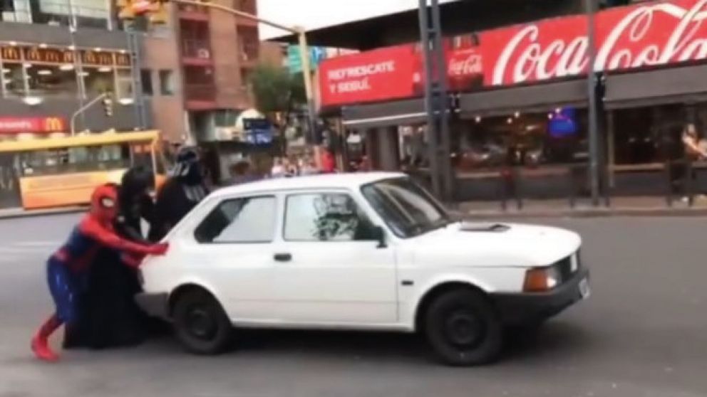 El momento en el que los "superhéroes" y el "villano" empujan el vehículo (Captura de video).