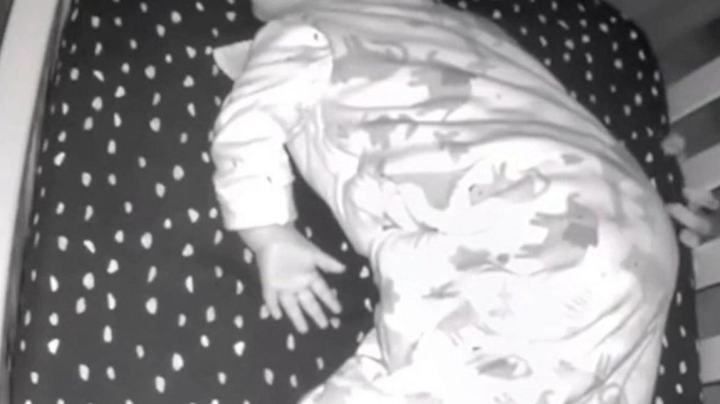 El video muestra una mano intentando agarrar a la beba desde debajo de su cuna.